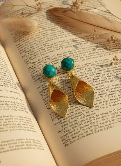 Gold Drop Earrings with Turquoise stones on an open book