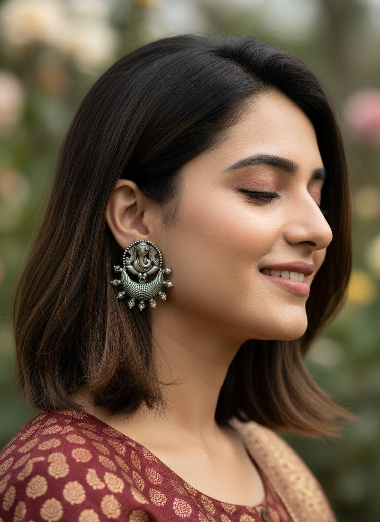 Model wearing Oxidized Ganesha Motif Stud Earrings with Intricate Detailing for Women - Special Occasions