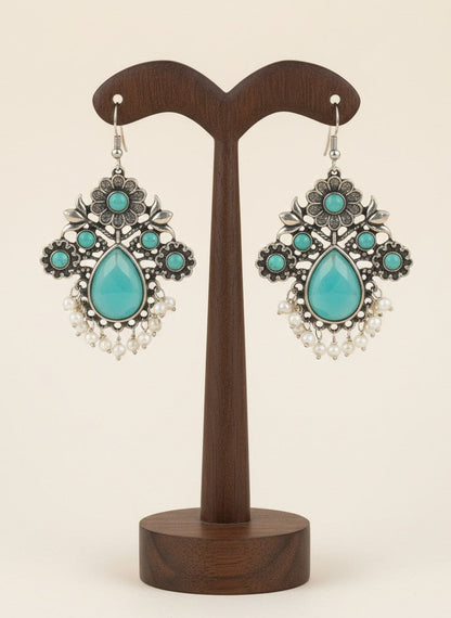On a display stand Silver Oxidized Floral Drop Earrings with Mint Stones & Pearl Cluster Detailing for Women - Office & Casual Wear 